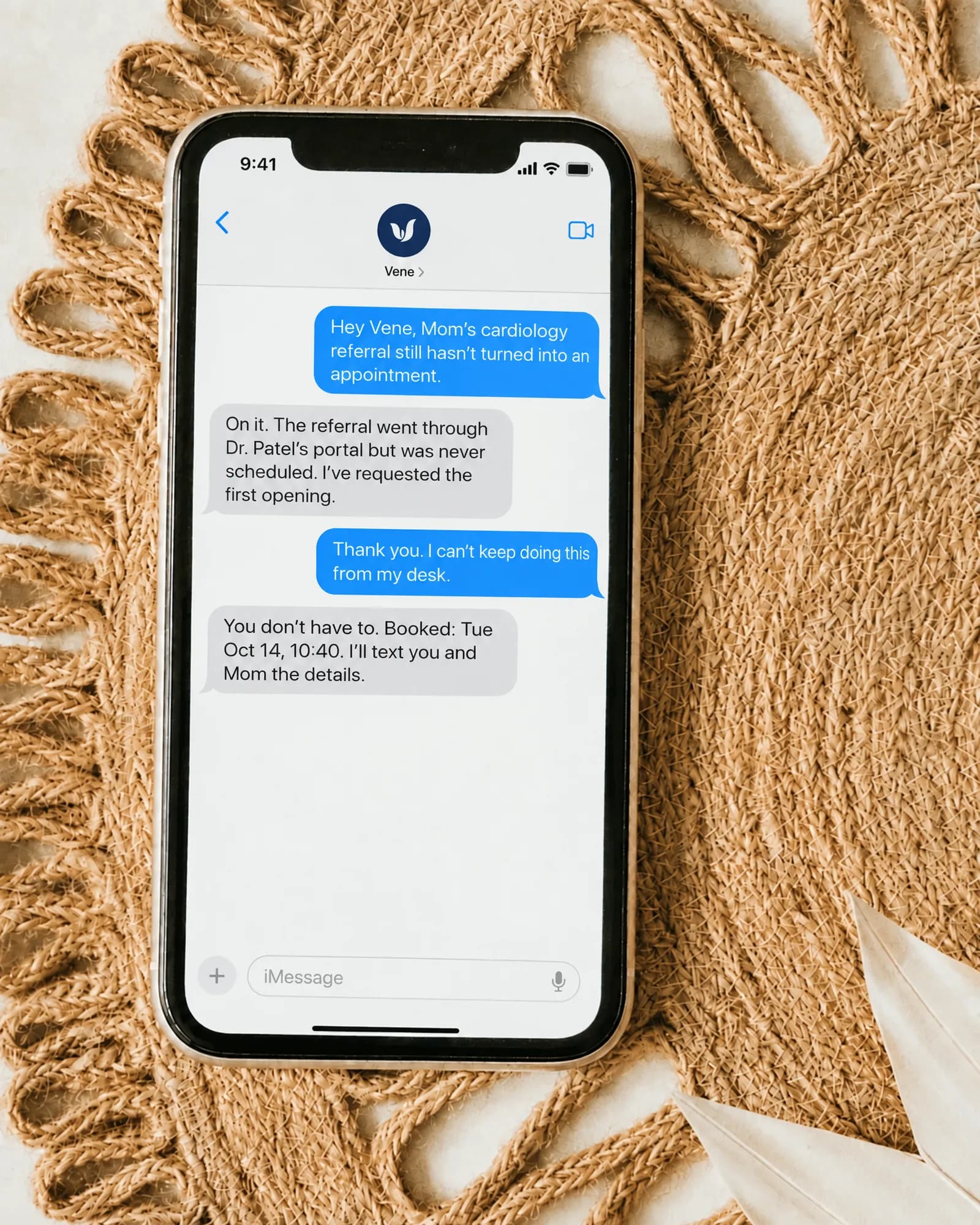A phone on a woven placemat, seen from above: Mom’s cardiology referral had never been scheduled, and Vene has booked it